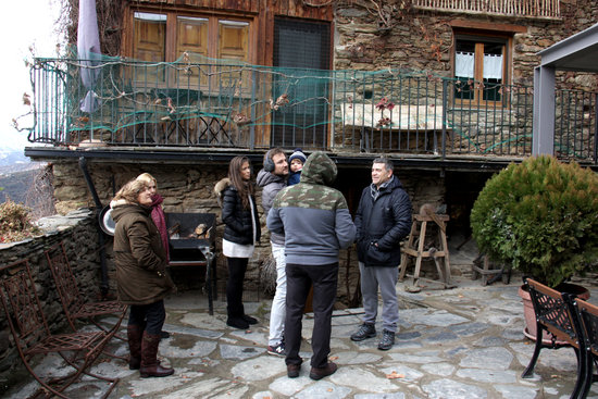 Una família a l'exterior de la casa rural Cal Serni de Calvinyà | ACN