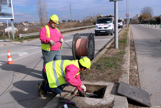 Dos empleats treballant en la connexió de la fibra òptica | ACN