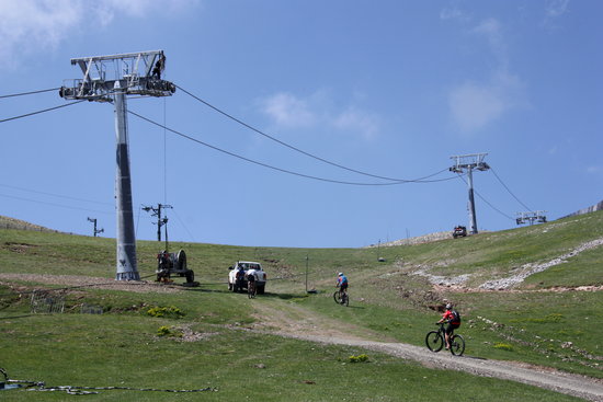Prolongació del telecabina de la Molina que està en obres on es veuen passar diversos ciclistes pel costat de la instal·lació | ACN