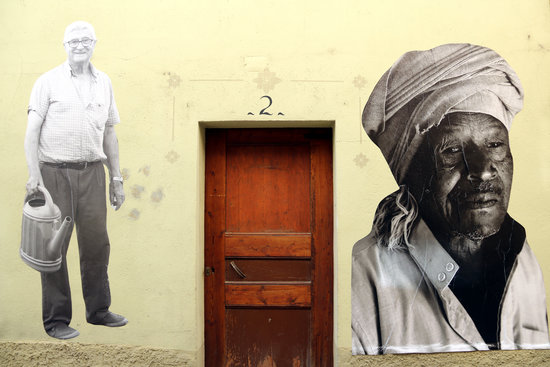 Façana d'Avià. A una banda, un veí d'Avià, i a l'altra, un home d'origen africà | ACN