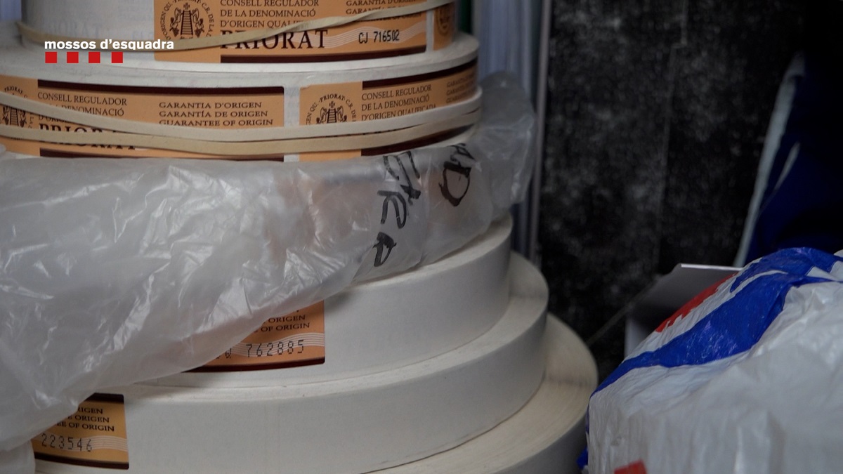 Pla detall d'un rotlle de cinta amb distintius de garantia falsificats de la DOQ Priorat intervinguts a Reserva de la Tierra. Foto del 21 d'octubre del 2021 (Horitzontal).