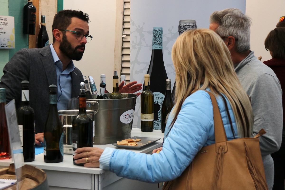 Pla mig del representant d'un celler dialogant amb una parella a la Festa del Vi de Gandesa. Imatge del 4 de novembre de 2018. (horitzontal)