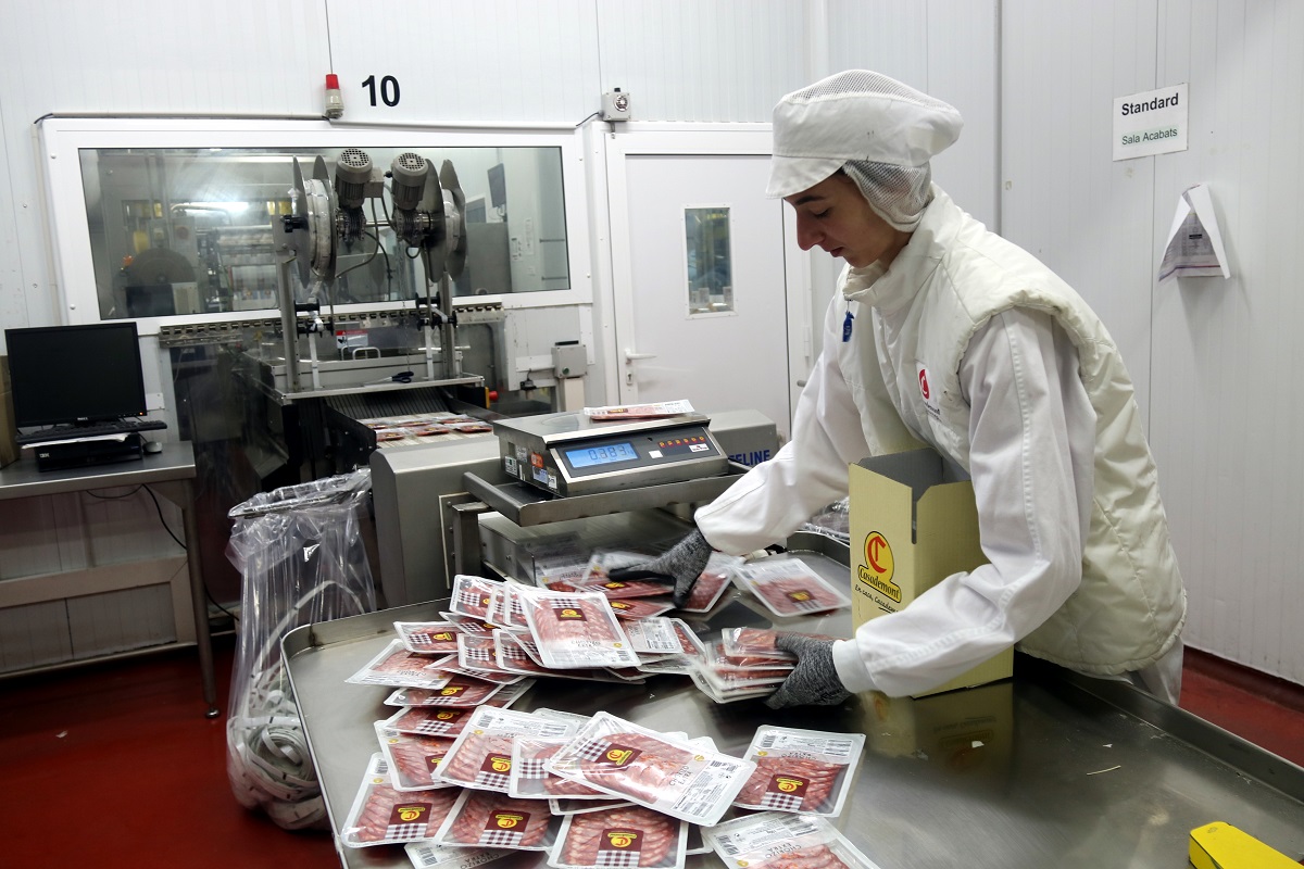 Una treballadora encaixant embotit llescat a la planta que Casademont té a Bonmatí, aquest 27 de setembre del 2019 (Horitzontal)